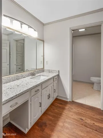 a bathroom with a granite countertop sink mirror and toilet