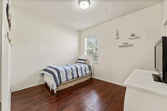 a room with a bed and wooden floor