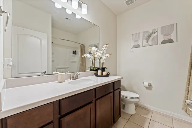 a bathroom with a sink vanity granite and toilet