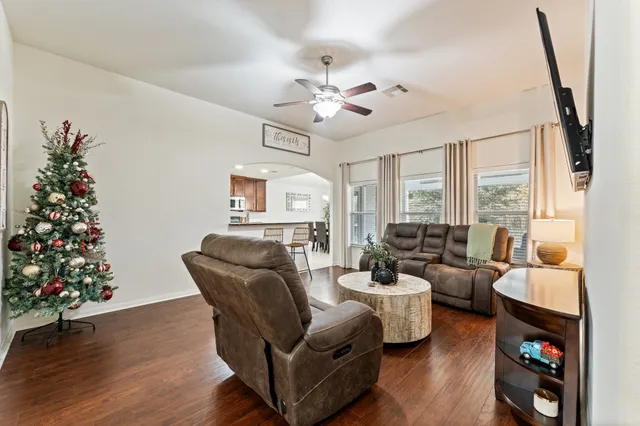 a living room with furniture flower pot and a large window