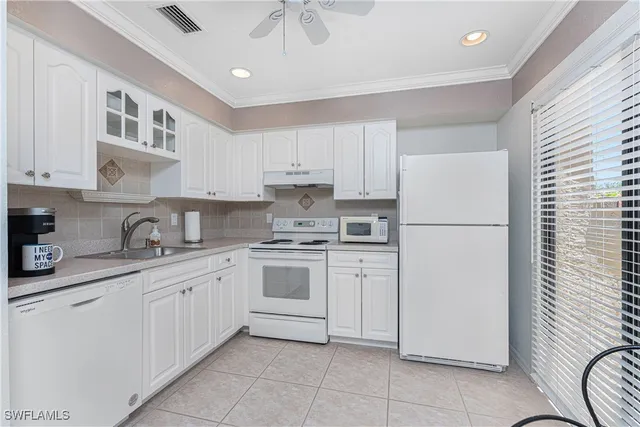 a kitchen with white cabinets and white appliances