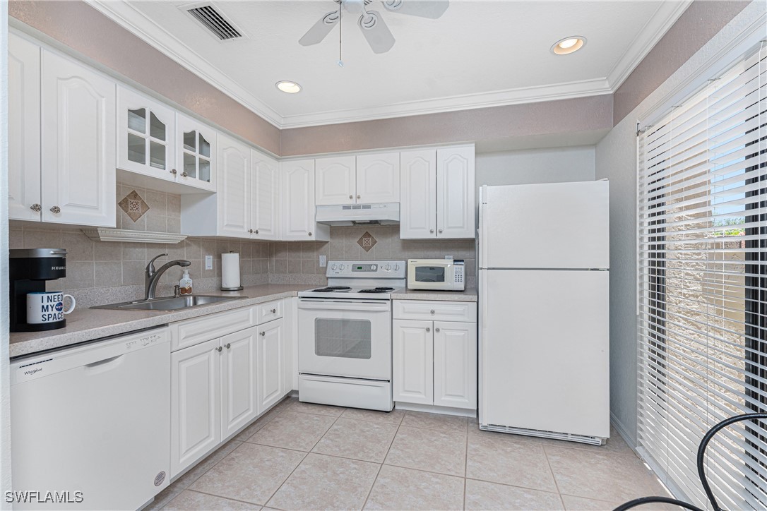 13100 South McCall Road, Unit 112 Port Charlotte, FL 33981 - Photo 11 of 45 a kitchen with white cabinets and white appliances