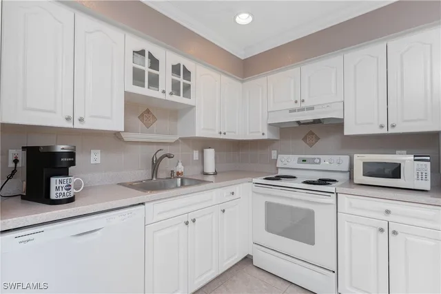 a kitchen with white cabinets and white appliances