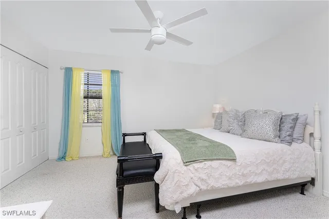 a bedroom with a bed and a ceiling fan