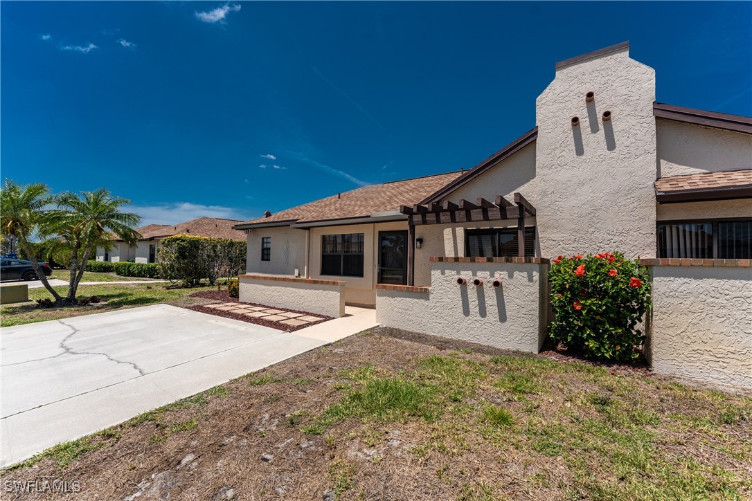 13100 South McCall Road, Unit 112 Port Charlotte, FL 33981 - Photo 30 of 45 a front view of a house with a garden and yard