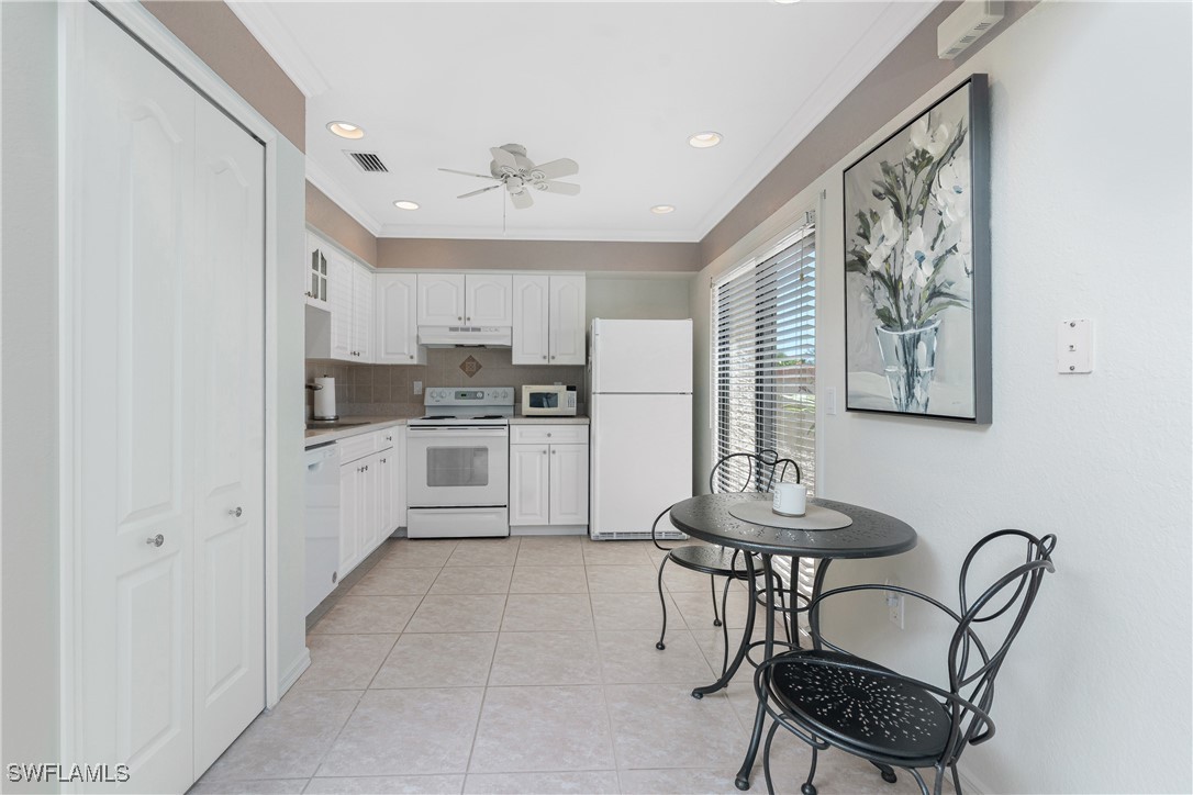13100 South McCall Road, Unit 112 Port Charlotte, FL 33981 - Photo 10 of 45 a kitchen with stainless steel appliances kitchen island a table chairs and a refrigerator