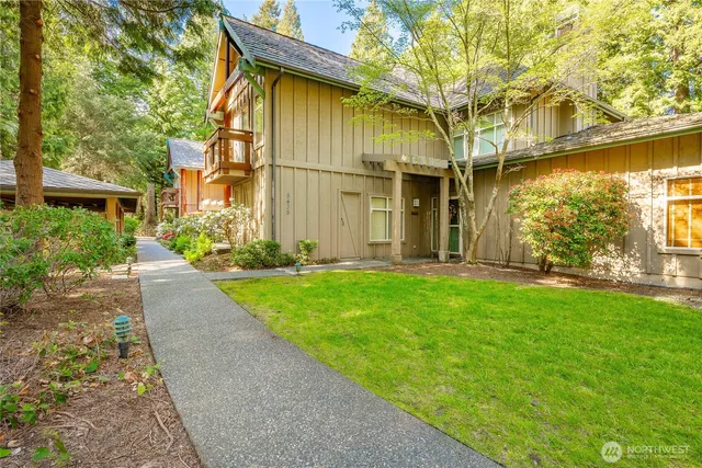a front view of a house with a yard and potted plants