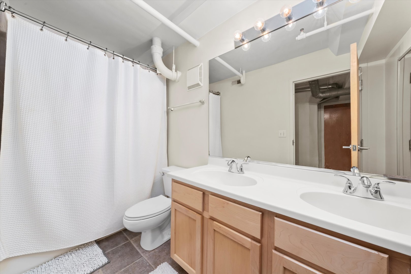 1601 South Michigan Avenue, Unit 108 Chicago, IL 60616 - Photo 24 of 36 a bathroom with a double vanity sink mirror and toilet