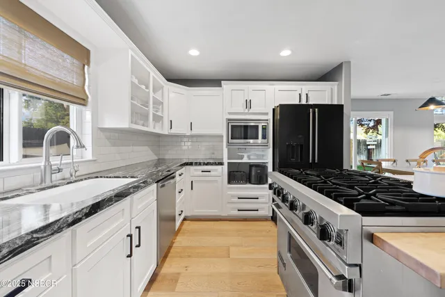 a kitchen with stainless steel appliances granite countertop a stove and a sink