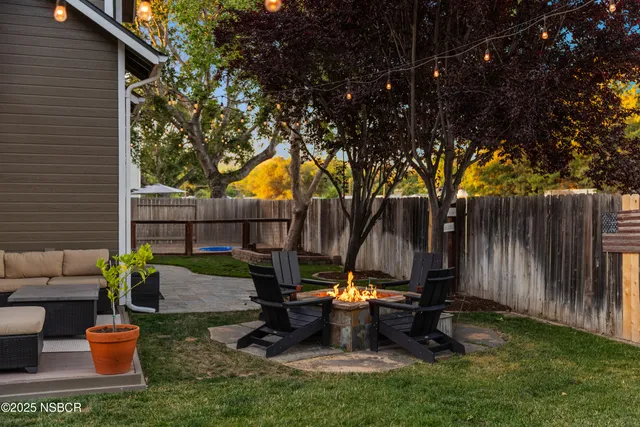 a view of backyard with a table and chairs a barbeque and a swing