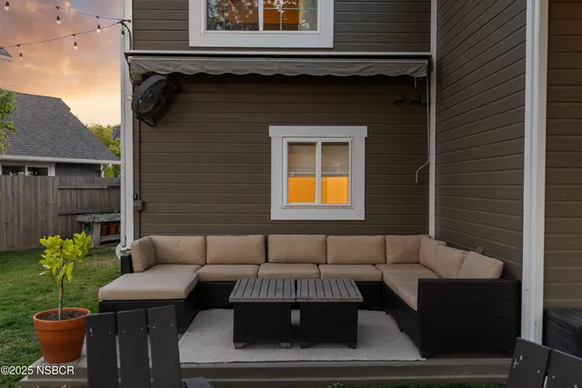a view of a patio with couches table and chairs and potted plants