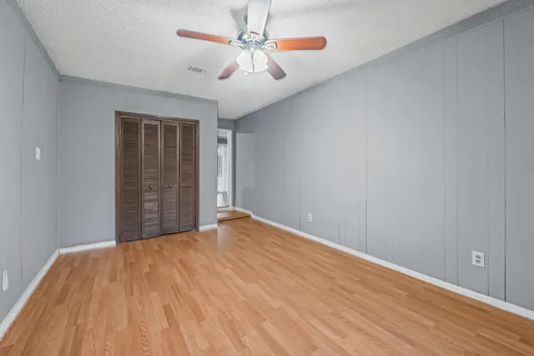 a view of an empty room with wooden floor