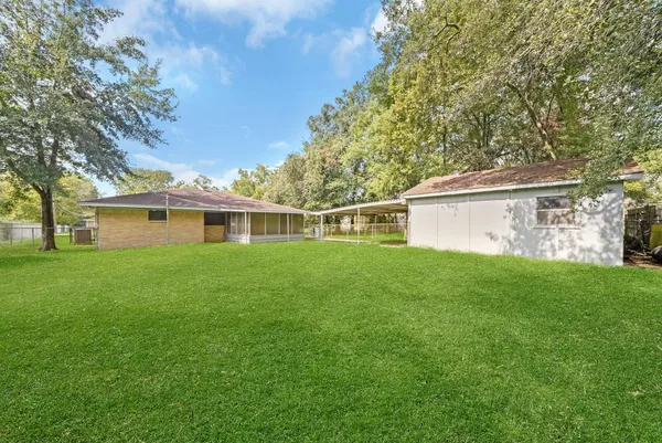a view of an empty room with wooden floor and door