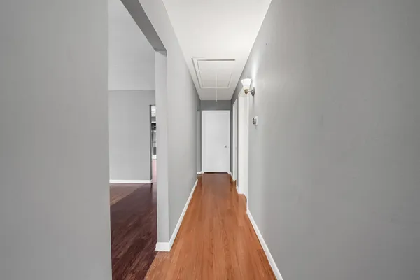 a view of a hallway with wooden floor and staircase