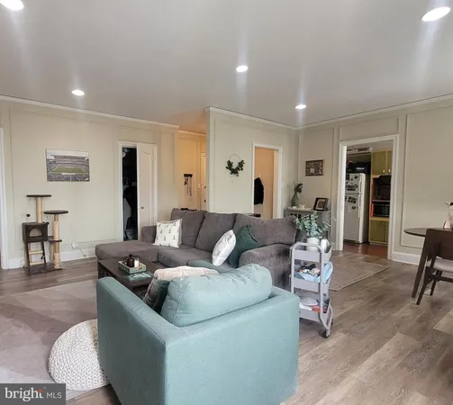 a living room with furniture and view of kitchen