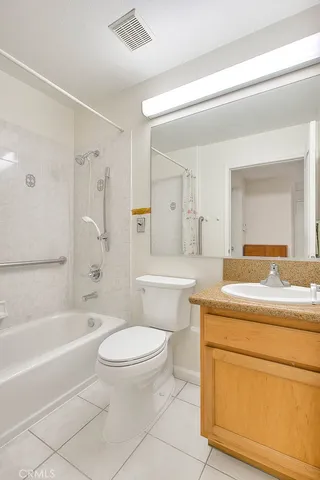 a bathroom with a granite countertop toilet a sink and a bathtub