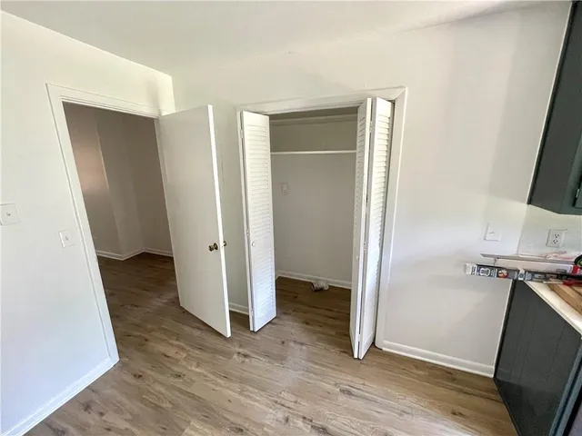 an empty room with wooden floor and a bathroom