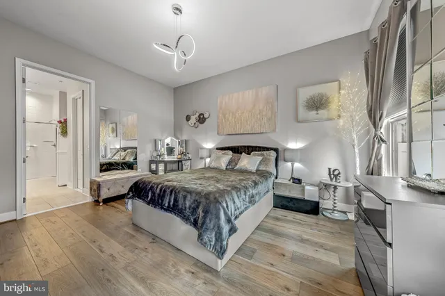 a spacious bedroom with a bed a table and painting