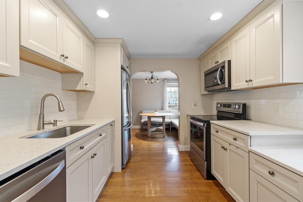 167 Gates Pond Road Berlin, MA 01503 - Photo 15 of 32 a kitchen with white cabinets a sink dishwasher and a stove with wooden floor