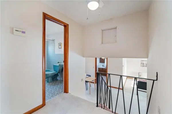 an empty room with windows and ceiling fan