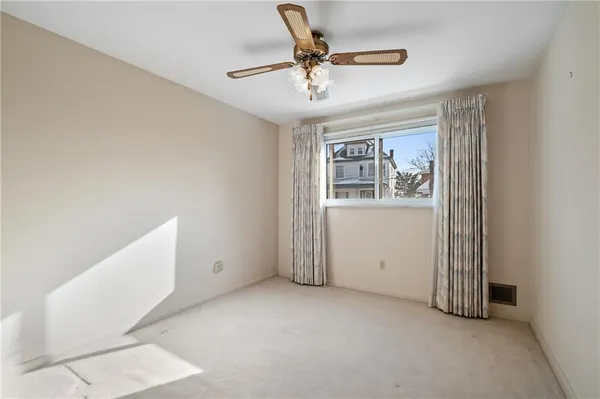 an empty room with a chandelier fan