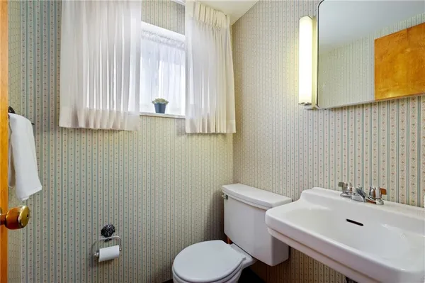 a bathroom with a sink a toilet and mirror