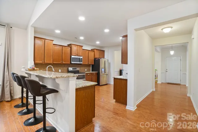 a view of kitchen with kitchen island stainless steel appliances refrigerator stove microwave and cabinets