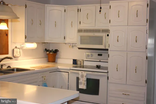 a kitchen with white cabinets and white appliances