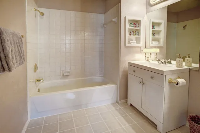 a view of a house with a small yard and a large tree