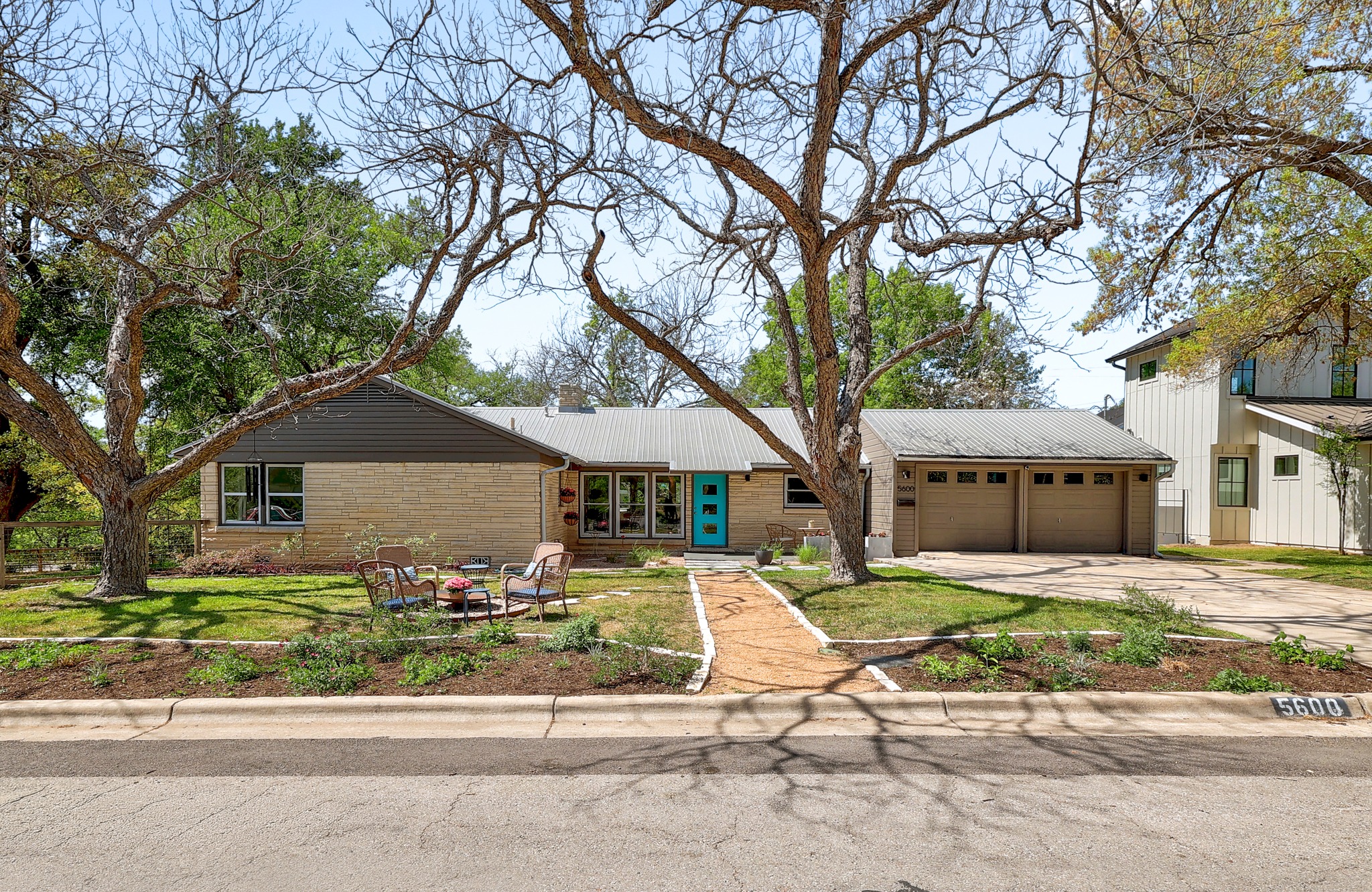 5600 Bull Creek Road Austin, TX 78756 - Photo 1 of 33 a front view of a house with a garden and trees