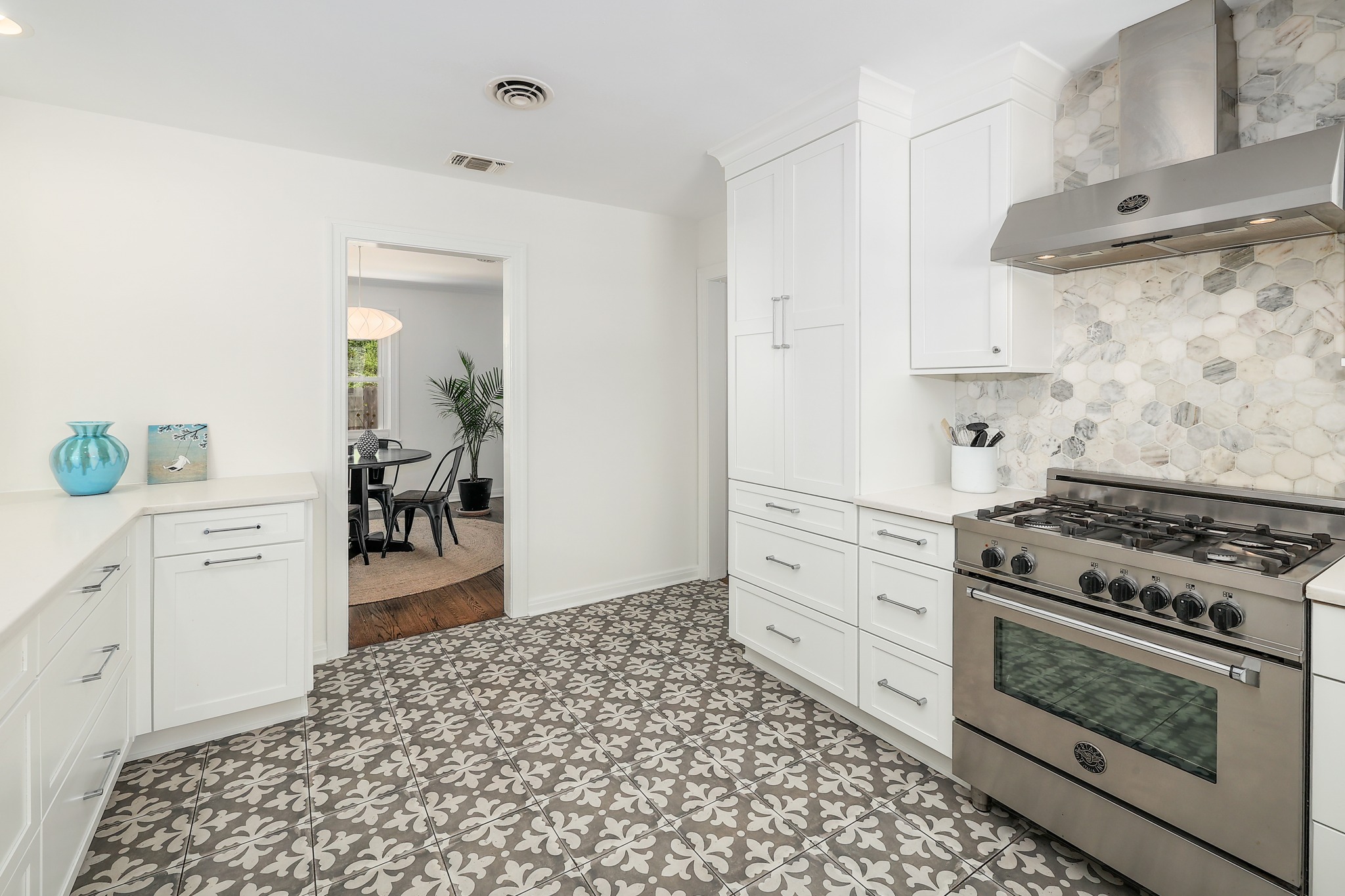 5600 Bull Creek Road Austin, TX 78756 - Photo 11 of 33 a kitchen with a stove and white cabinets