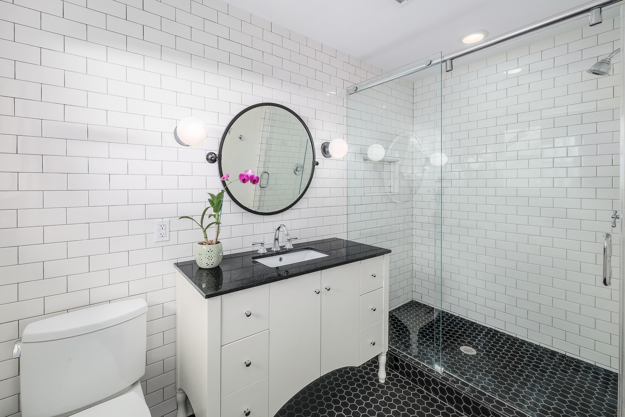 5600 Bull Creek Road Austin, TX 78756 - Photo 16 of 33 a bathroom with a sink a toilet and a mirror