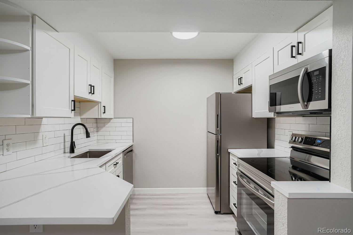 3050 West 32nd Avenue, Unit 102C Denver, CO 80211 - Photo 1 of 36 a kitchen with stainless steel appliances granite countertop a sink stove and refrigerator