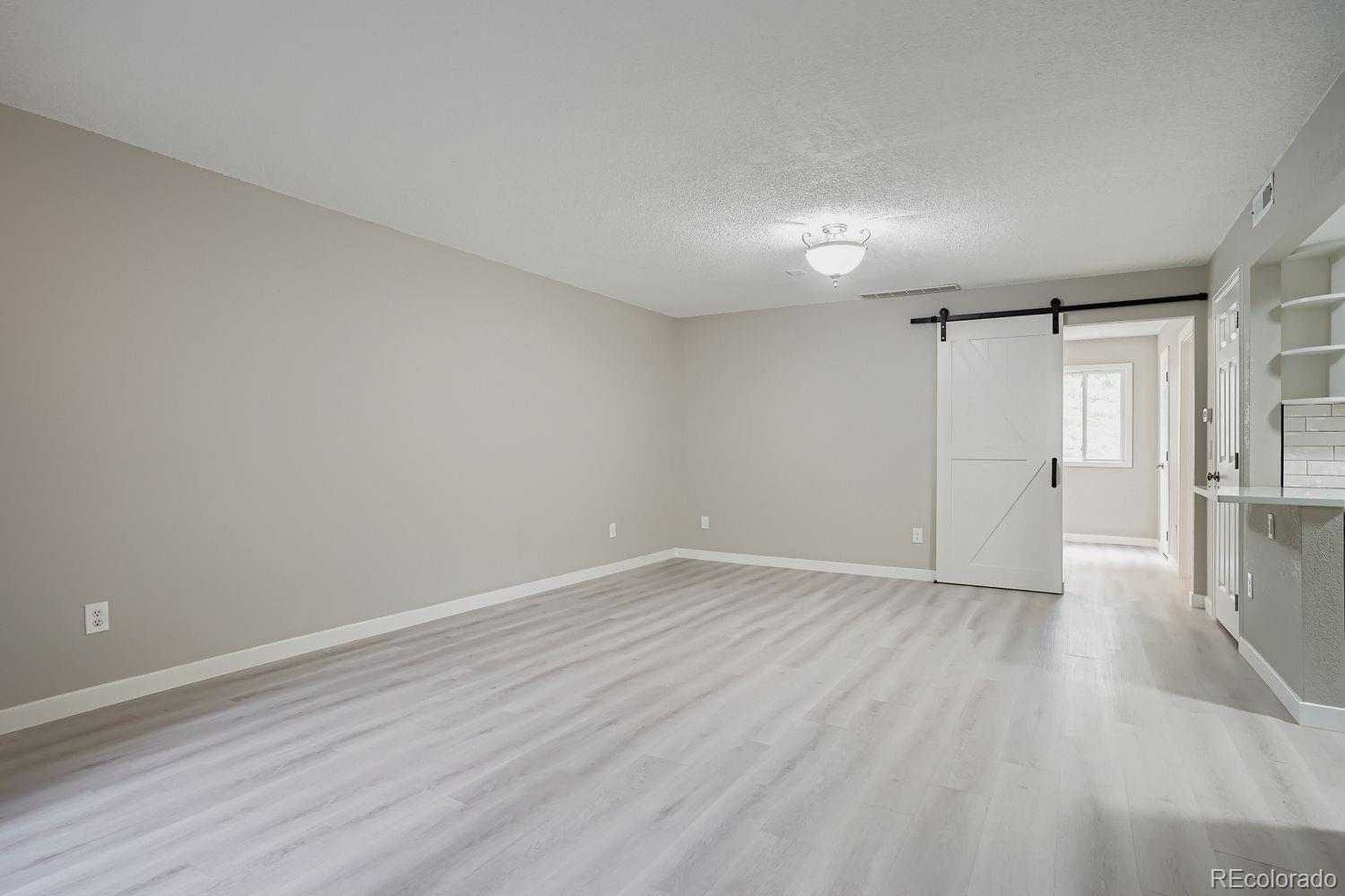 3050 West 32nd Avenue, Unit 102C Denver, CO 80211 - Photo 7 of 36 a view of an empty room with wooden floor