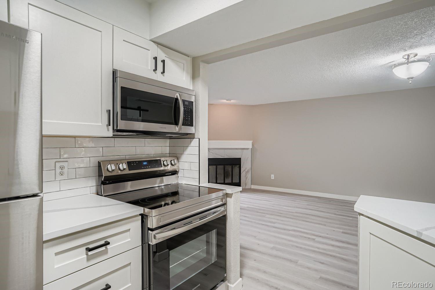 3050 West 32nd Avenue, Unit 102C Denver, CO 80211 - Photo 9 of 36 a kitchen with cabinets stainless steel appliances and a wooden floor