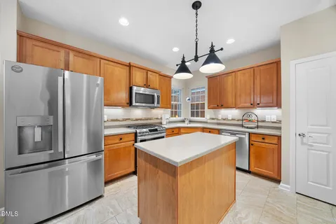 a large kitchen with stainless steel appliances granite countertop a granite counter tops and a view of living room