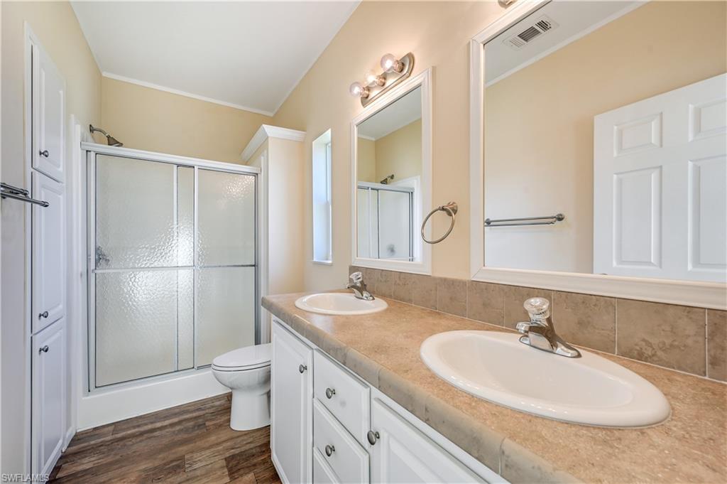 22 Enchanting Boulevard, Unit E22 Naples, FL 34112 - Photo 12 of 20 a bathroom with a granite countertop sink and a mirror