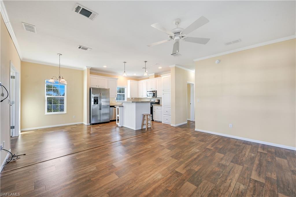 22 Enchanting Boulevard, Unit E22 Naples, FL 34112 - Photo 3 of 20 a view of a kitchen with a kitchen island wooden floor and a window