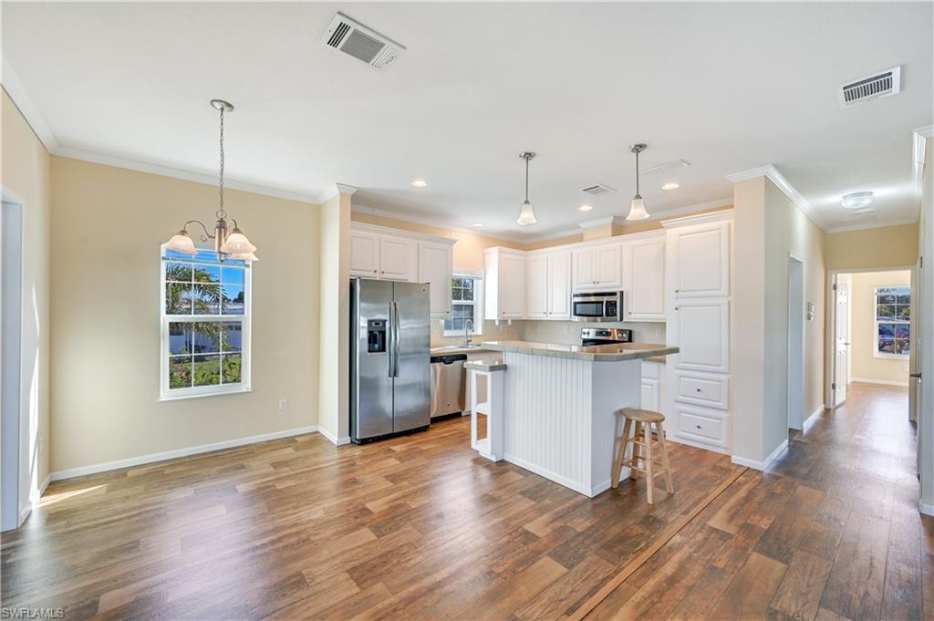 22 Enchanting Boulevard, Unit E22 Naples, FL 34112 - Photo 4 of 20 a kitchen with kitchen island white cabinets and stainless steel appliances