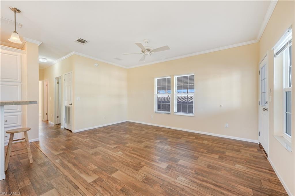22 Enchanting Boulevard, Unit E22 Naples, FL 34112 - Photo 5 of 20 a view of an empty room with wooden floor and a window