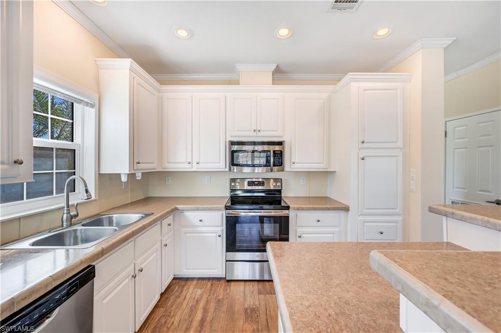 22 Enchanting Boulevard, Unit E22 Naples, FL 34112 - Photo 6 of 20 a kitchen with stainless steel appliances granite countertop a sink stove and refrigerator