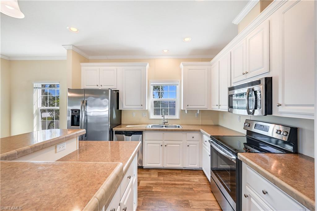22 Enchanting Boulevard, Unit E22 Naples, FL 34112 - Photo 7 of 20 a kitchen with stainless steel appliances granite countertop a sink stove and refrigerator