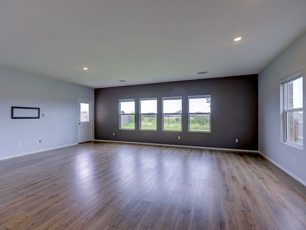 1716 Frontenac Street Leander, TX 78641 - Photo 13 of 34 a view of an empty room with wooden floor and a window