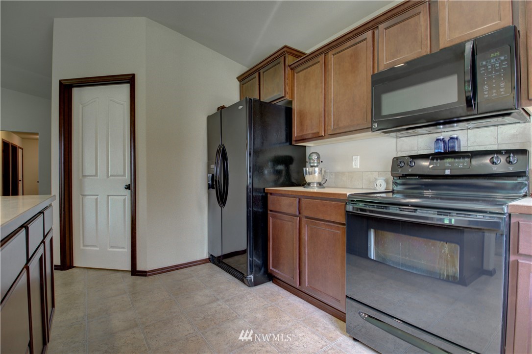 5138 180th Trail Southwest Rochester, WA 98579 - Photo 11 of 33 a kitchen with stainless steel appliances granite countertop a stove microwave and refrigerator