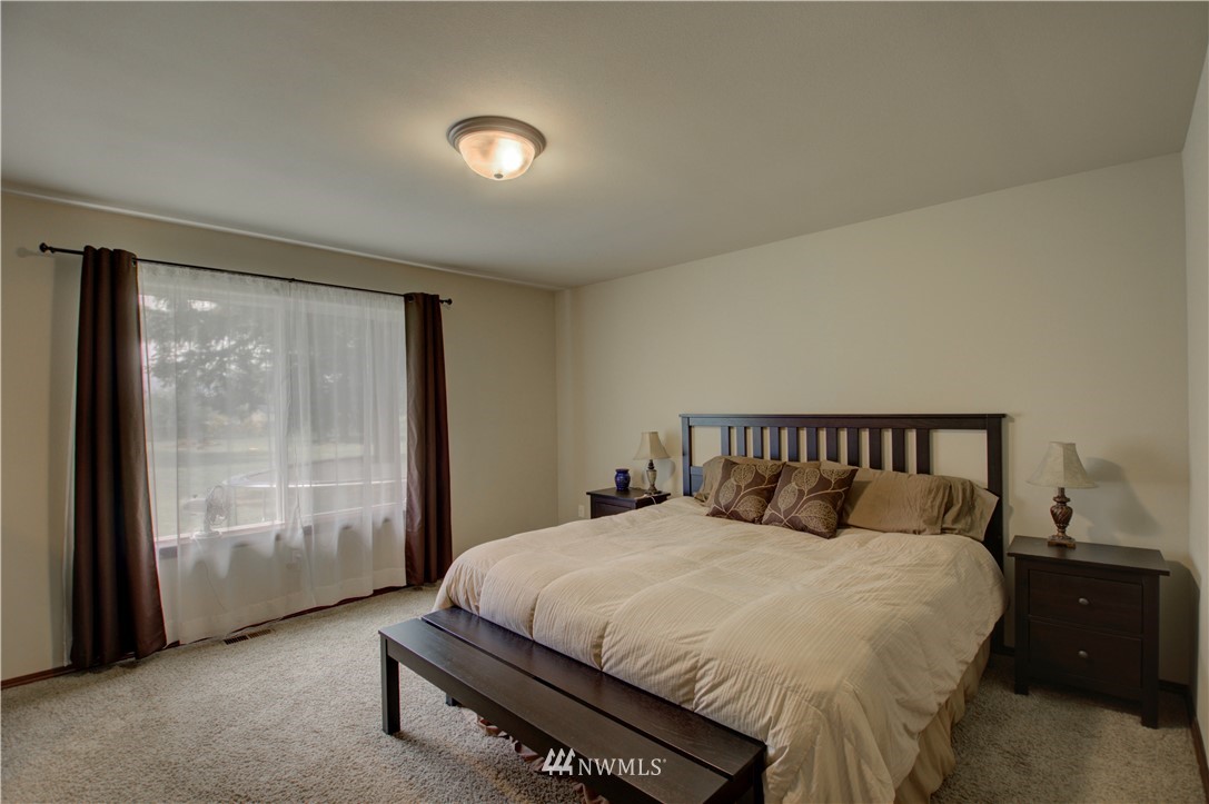 5138 180th Trail Southwest Rochester, WA 98579 - Photo 13 of 33 a bed sitting in a bedroom next to a window