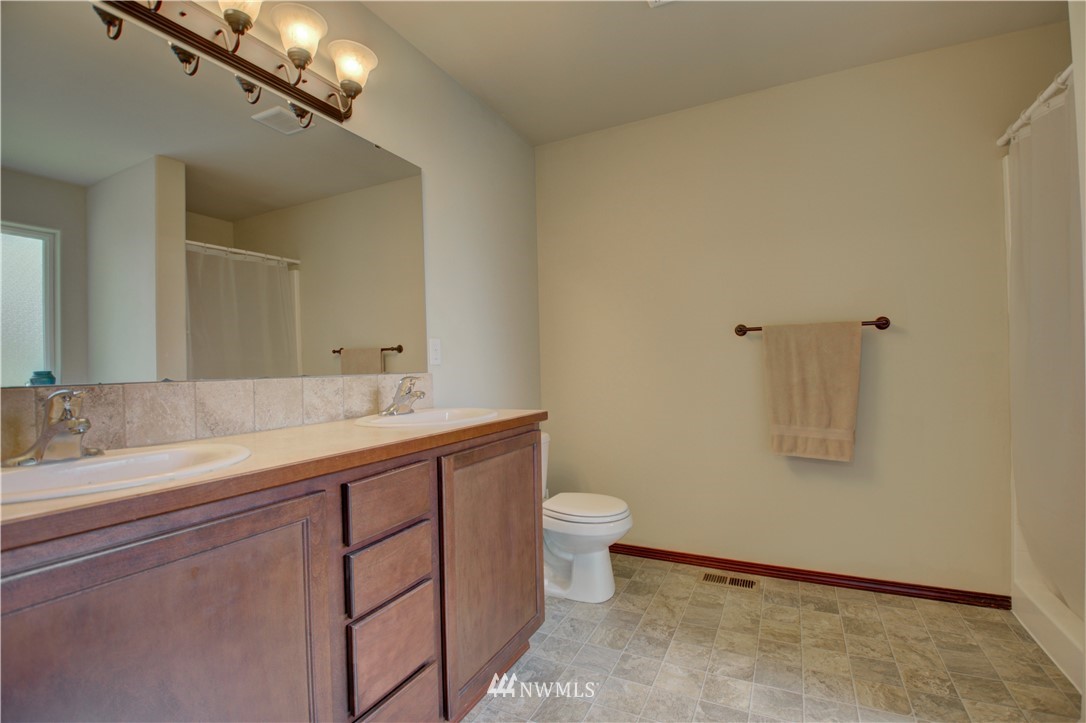 5138 180th Trail Southwest Rochester, WA 98579 - Photo 17 of 33 a bathroom with a granite countertop sink a toilet and mirror