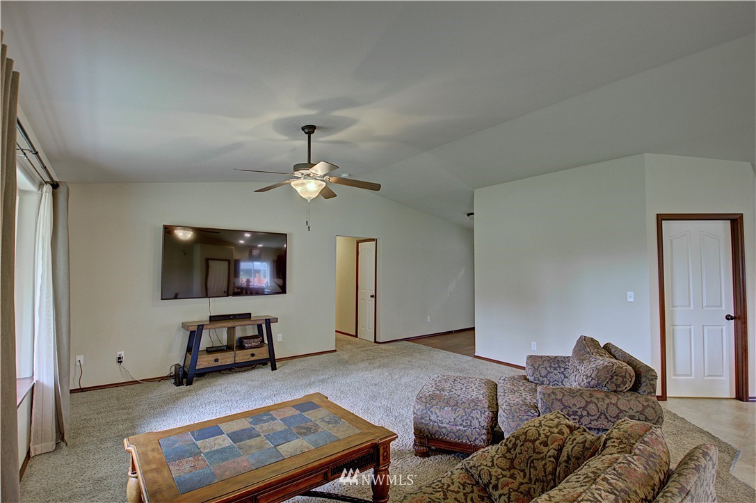 5138 180th Trail Southwest Rochester, WA 98579 - Photo 3 of 33 a spacious bedroom with a bed a flat screen tv and a couch