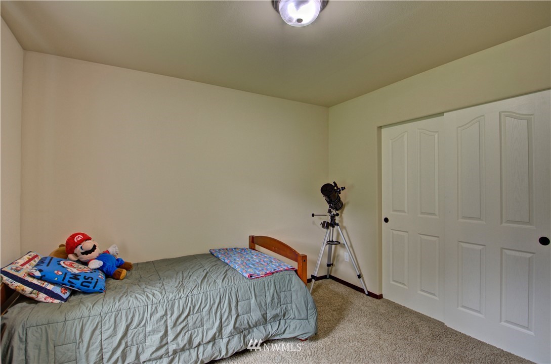 5138 180th Trail Southwest Rochester, WA 98579 - Photo 24 of 33 a bedroom with a bed and a chandelier