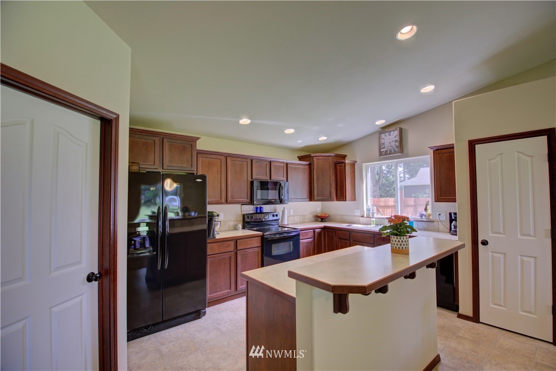 5138 180th Trail Southwest Rochester, WA 98579 - Photo 8 of 33 a kitchen with refrigerator and cabinets