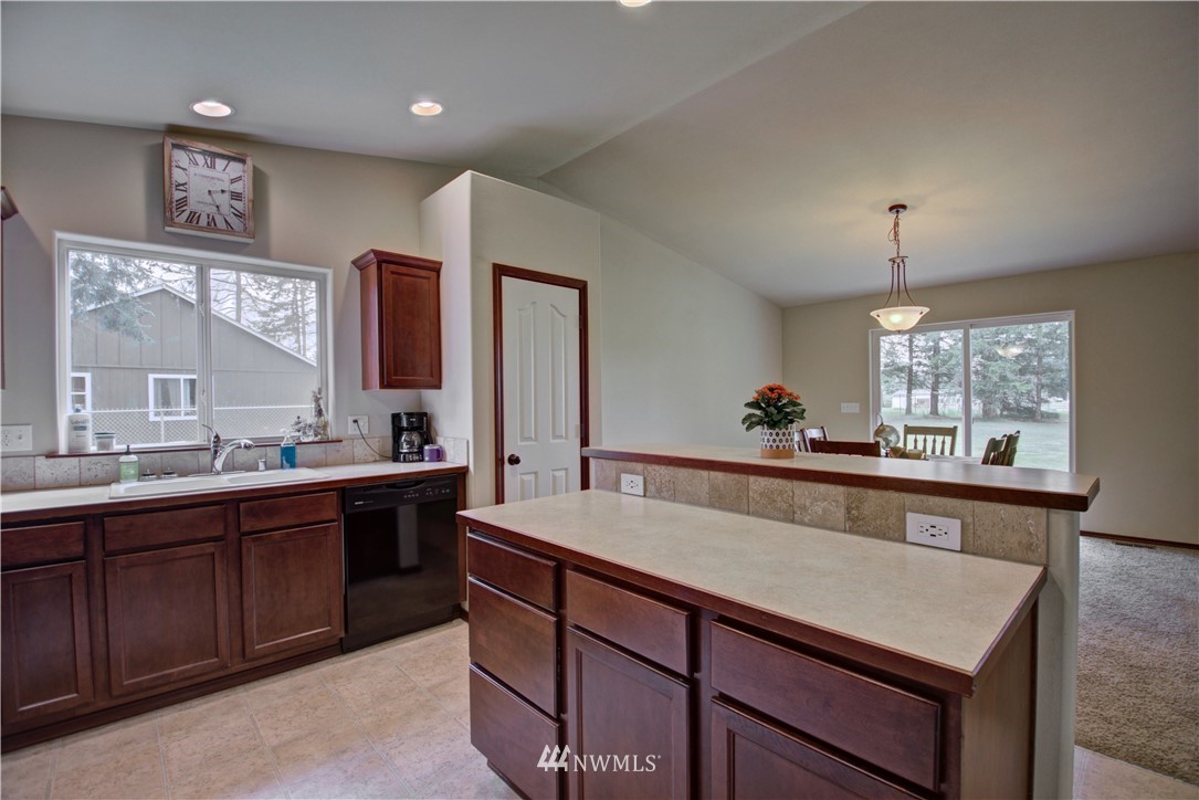 5138 180th Trail Southwest Rochester, WA 98579 - Photo 9 of 33 a large kitchen with kitchen island a sink appliances and a counter top space
